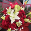 Bouquet of red roses and white lilies wrapped in red paper