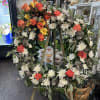 Large floral wreath on an easel with orange roses and white daisies