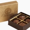 Box of assorted chocolates with a gold lid and brown tray