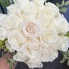 Bouquet of white roses with small green foliage accents