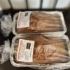 Two wrapped loaves of pumpkin sweet bread in foil pans