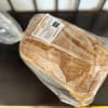 Loaf of sourdough bread in plastic wrap with a label