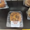 Banana nut muffin in a clear plastic clamshell container