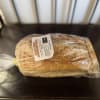Wrapped loaf of sourdough bread on a dark table