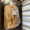 Wrapped loaf of rosemary garlic sourdough bread with a product label