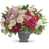 Pink and cream roses with lilies in a gray pedestal vase