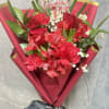 A romantic hand-tied bouquet featuring rich red roses, carnations, and alstroemeria, delicately