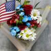 Bouquet of red roses, blue and white daisies, and an American flag