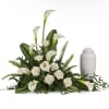 Pure white calla lilies and roses form a serene, sculpted sympathy arrangement