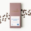 Box of dark chocolate espresso with coffee beans scattered around it