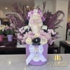 Decorative skull arrangement with purple and white flowers in a lavender box