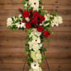 Cross-shaped floral arrangement with red and white flowers on a stand