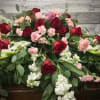 Casket spray with red roses, pink carnations, and white flowers
