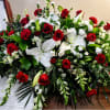 Large red and white floral casket spray with roses and lilies