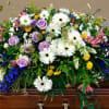 Large casket spray with white daisies, lavender roses, and mixed blooms