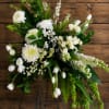 White floral standing spray on a metal easel