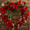 Heart-shaped red floral wreath on an easel with a ribbon bow