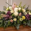Large casket spray with white, pink, yellow, and purple flowers