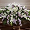 White lilies and lavender roses arranged on a casket