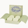 Open gift box with round white soaps and freesia branding