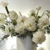 Seasonal white flowers in clear vase. Pictured are roses, peony. orchids, ranunculus