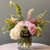 Pink and white mixed flowers arranged in a clear glass vase