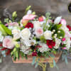 Low wooden box arrangement with white and pink roses, calla lilies, lilies, and red accent flowers