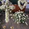 White floral funeral sprays and a heart-shaped wreath on stands
