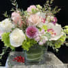 Mixed bouquet of white, pink, and green flowers in a clear glass vase