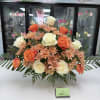 Arrangement of orange and white roses with peach chrysanthemums