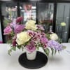 Lavender and cream rose bouquet in a white vase