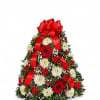 Christmas tree-shaped floral arrangement with red roses and white daisies, topped by a red bow