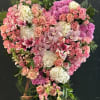 Heart-shaped floral standing arrangement in pink, peach, and white blooms