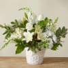White floral arrangement in a white woven basket