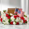 Red and white floral arrangement with two small American flags