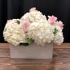 White hydrangeas with pink roses in a rectangular vase