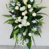 Tall white floral standing spray with roses and lilies on an easel