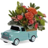 Flower arrangement in a turquoise ceramic truck planter