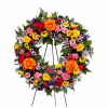 Colorful floral wreath on a black stand with roses and daisies