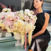 Large pastel rose arrangement in a white pedestal vase