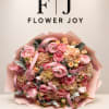 Large pink bouquet of roses, ranunculus, and hydrangeas wrapped in pink paper