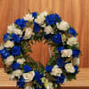Circular wreath of blue and white roses with gold butterfly accents