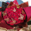 Bouquet of red roses wrapped in dark paper with butterfly decorations