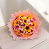 Pink-wrapped bouquet of sunflowers, gerbera daisies, and roses