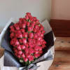 Large bouquet of pink roses wrapped in black and white paper