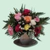 Mixed roses in a teacup vase on a saucer