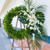 24" wreath covered in tropical green leaves. The flowers are roses and