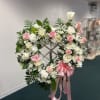 Heart-shaped wreath of pink and white roses with a pink ribbon