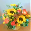 Mixed bouquet with sunflowers, roses, and daisies in a vase