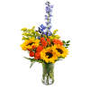 Bouquet of sunflowers, orange carnations, and blue delphinium in a clear glass vase